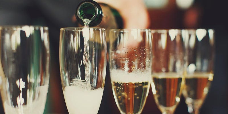 champagne poured into glasses for "No 'Pagne, No Gain" New Year's Eve Wine Dinner