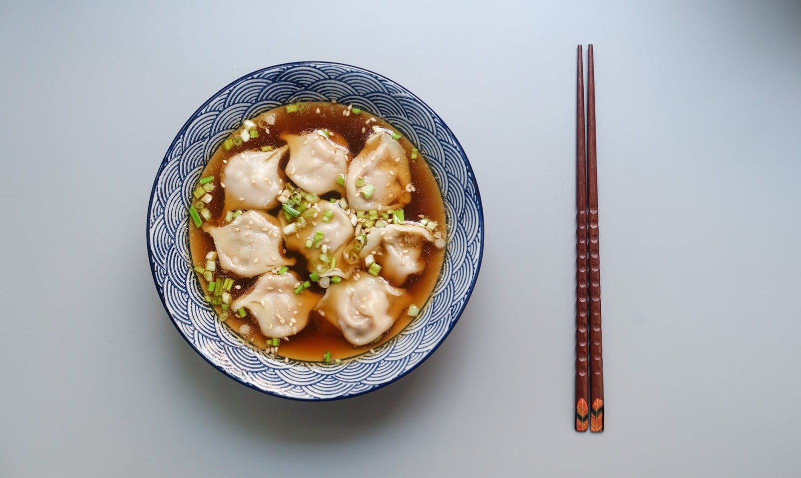 Asian dish on a plate next to chopsticks