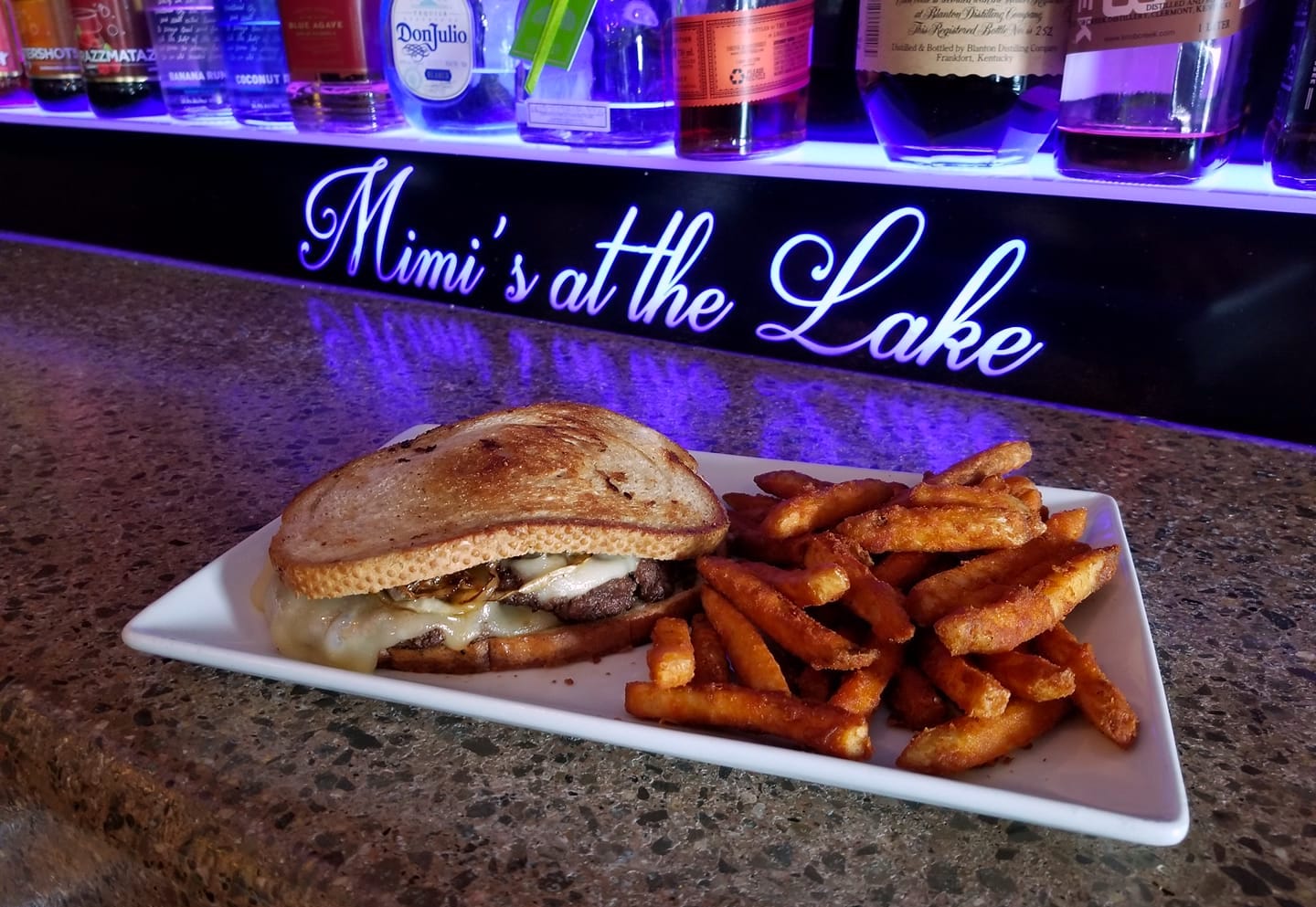 sandwhich & fries in front of lit Mimi's at the Lake sign