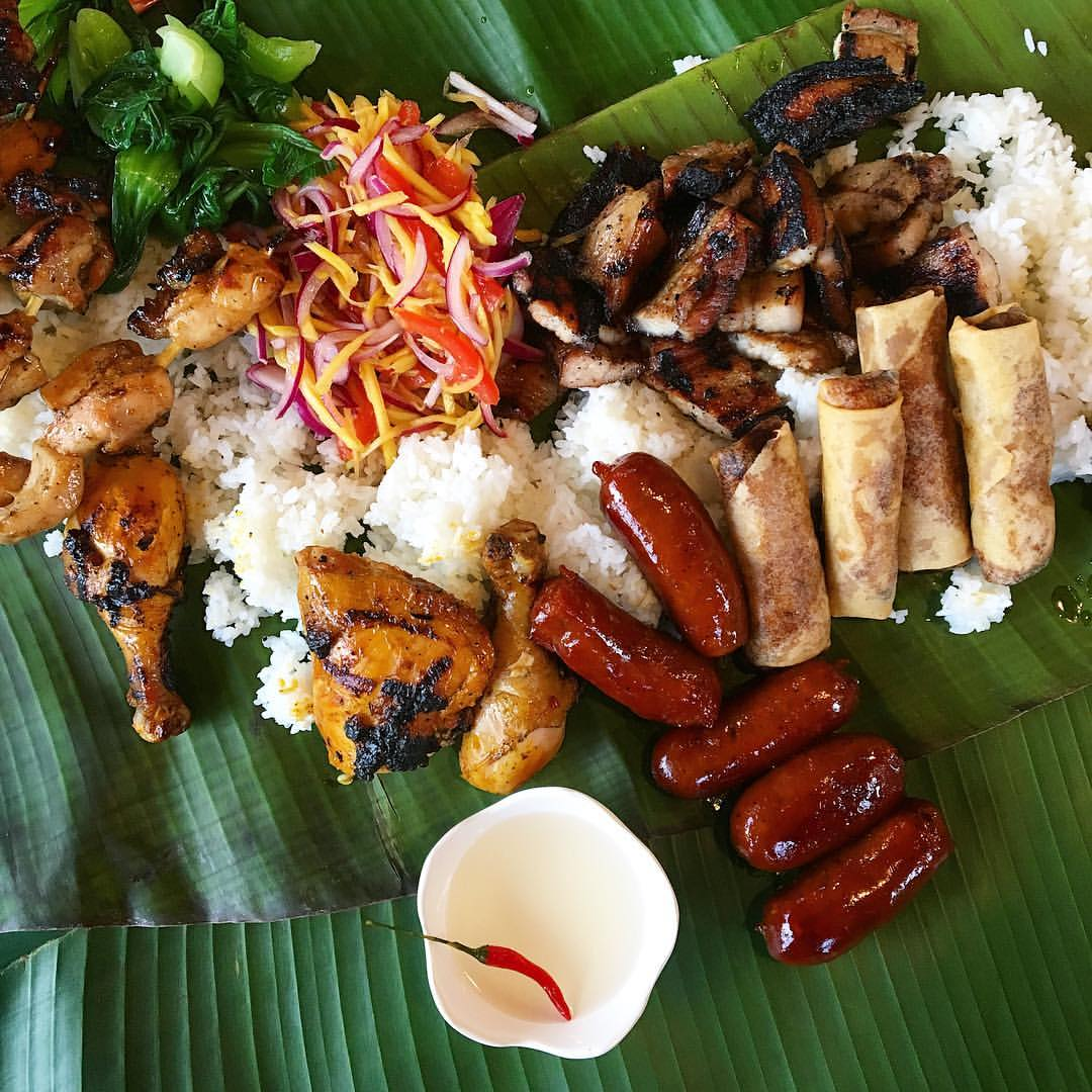 Filipino food spread chicken slaw and banana leaves