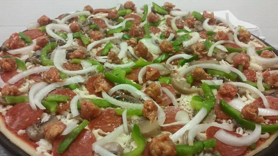 pizza topped with green peppers, onions, sausages, and pepperoni