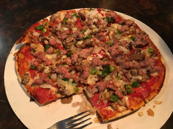 pizza with sausage, green pepper, and other toppings
