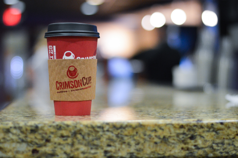 A red portable mug from Crimson Cup Coffee on a counter