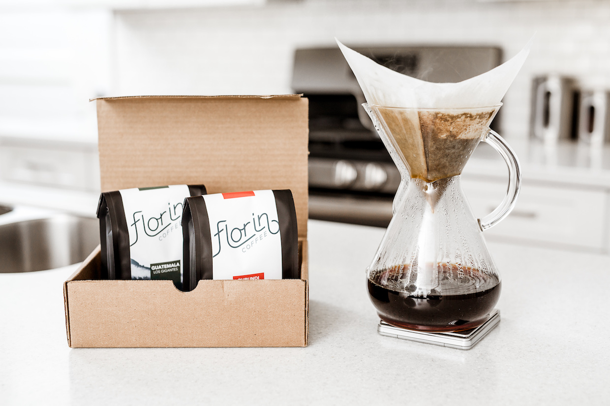 Packaged Florin Coffee in a cardboard box next to a hand-brewed pot