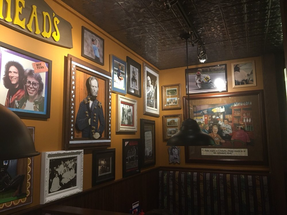 photographs and portraits of various celebrities line the orange walls of cherry street pub in lancaster, OH