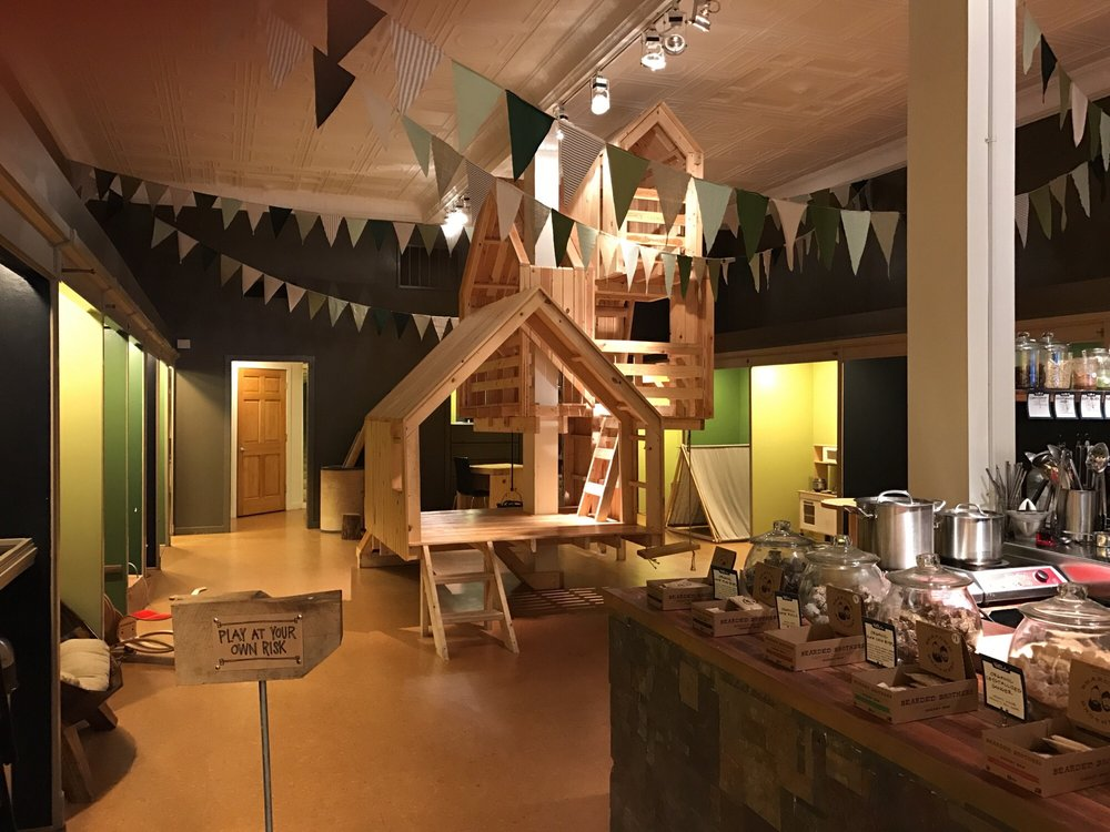 The inside of The Well, in Lancaster OH, which has walls painted various shades of green and indoor treehouses.