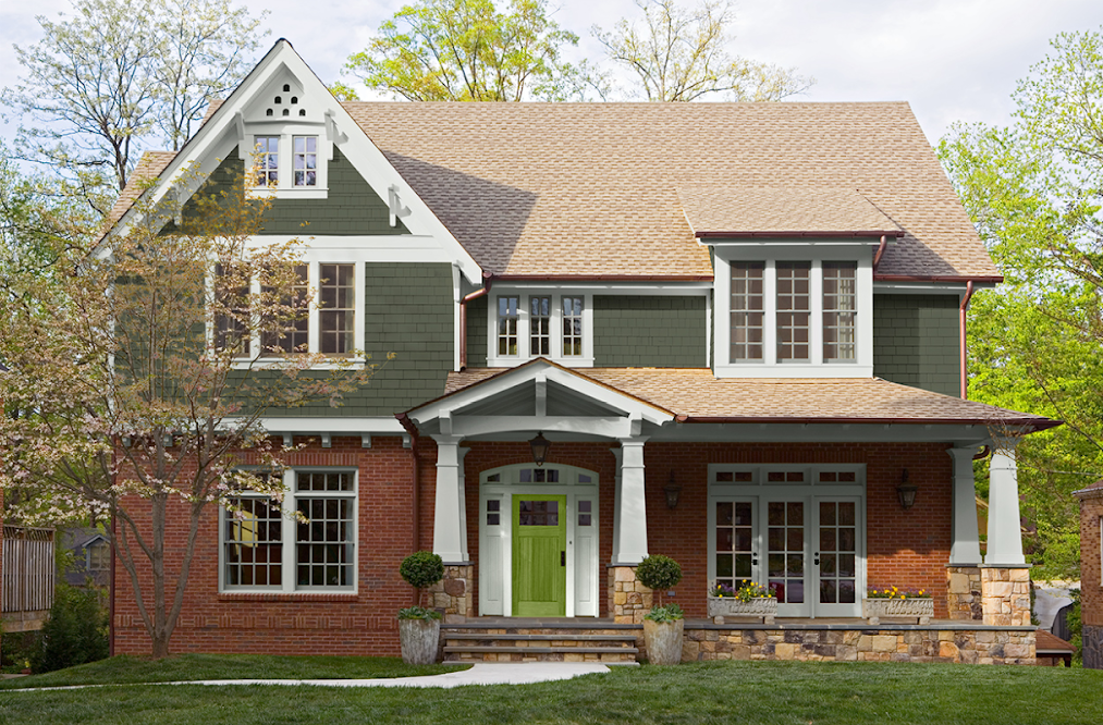 Red brick and green clapboard three-story home with white trim and accents