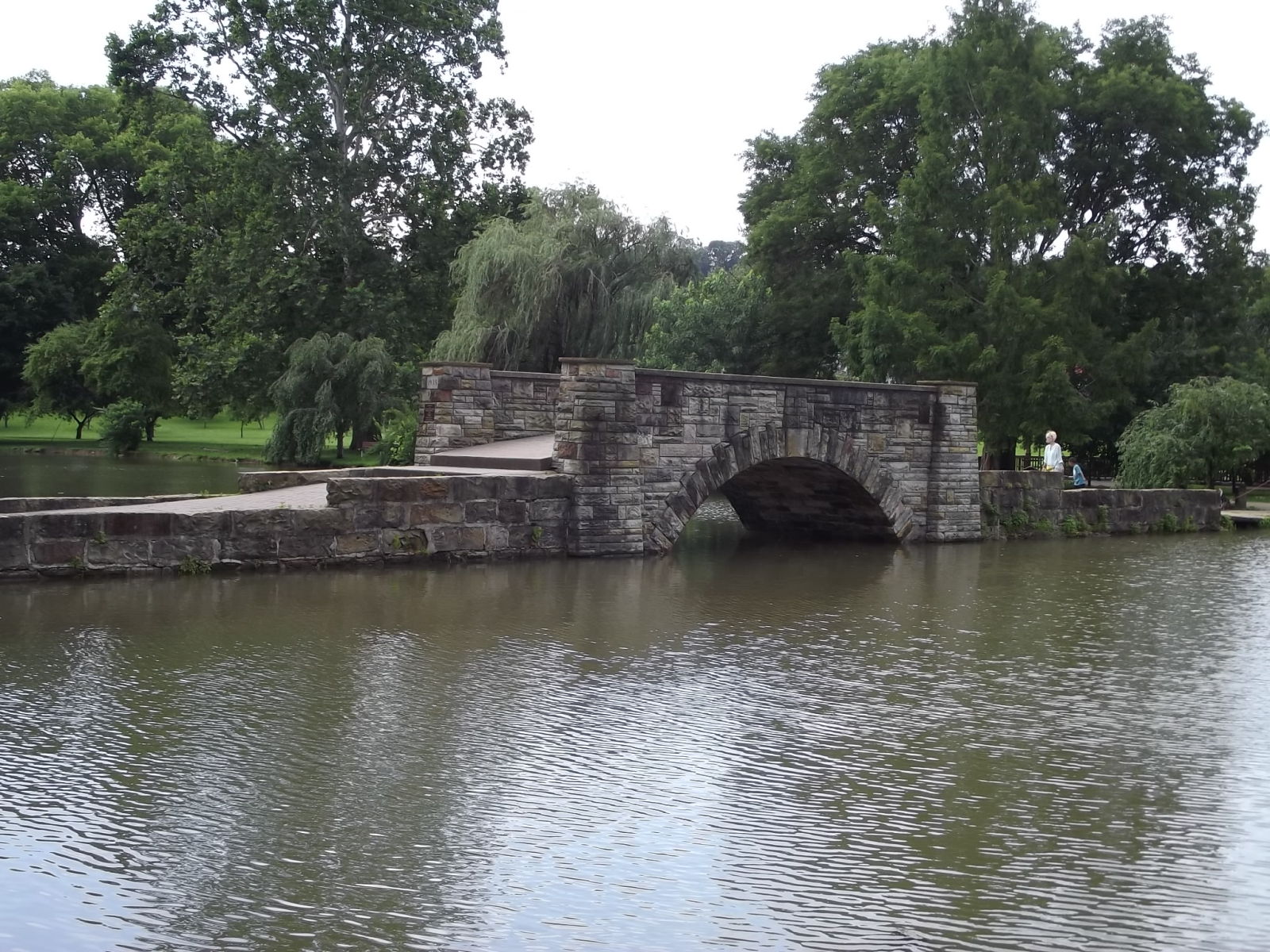 stone bridge over water with surrounding trees