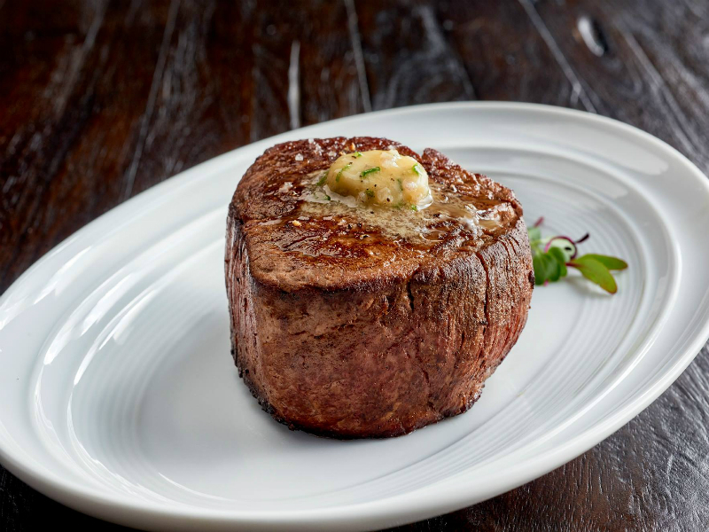 A plate of steak with melted butter from Mitchell's Steakhouse