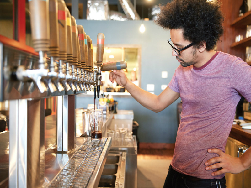 A male barista pouring a coffee drink