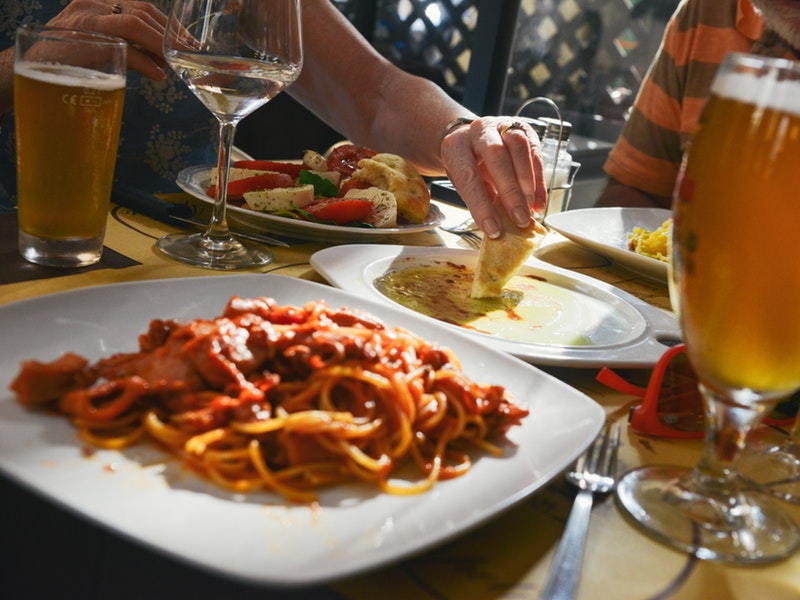 A table with Italian food, wine, and beer