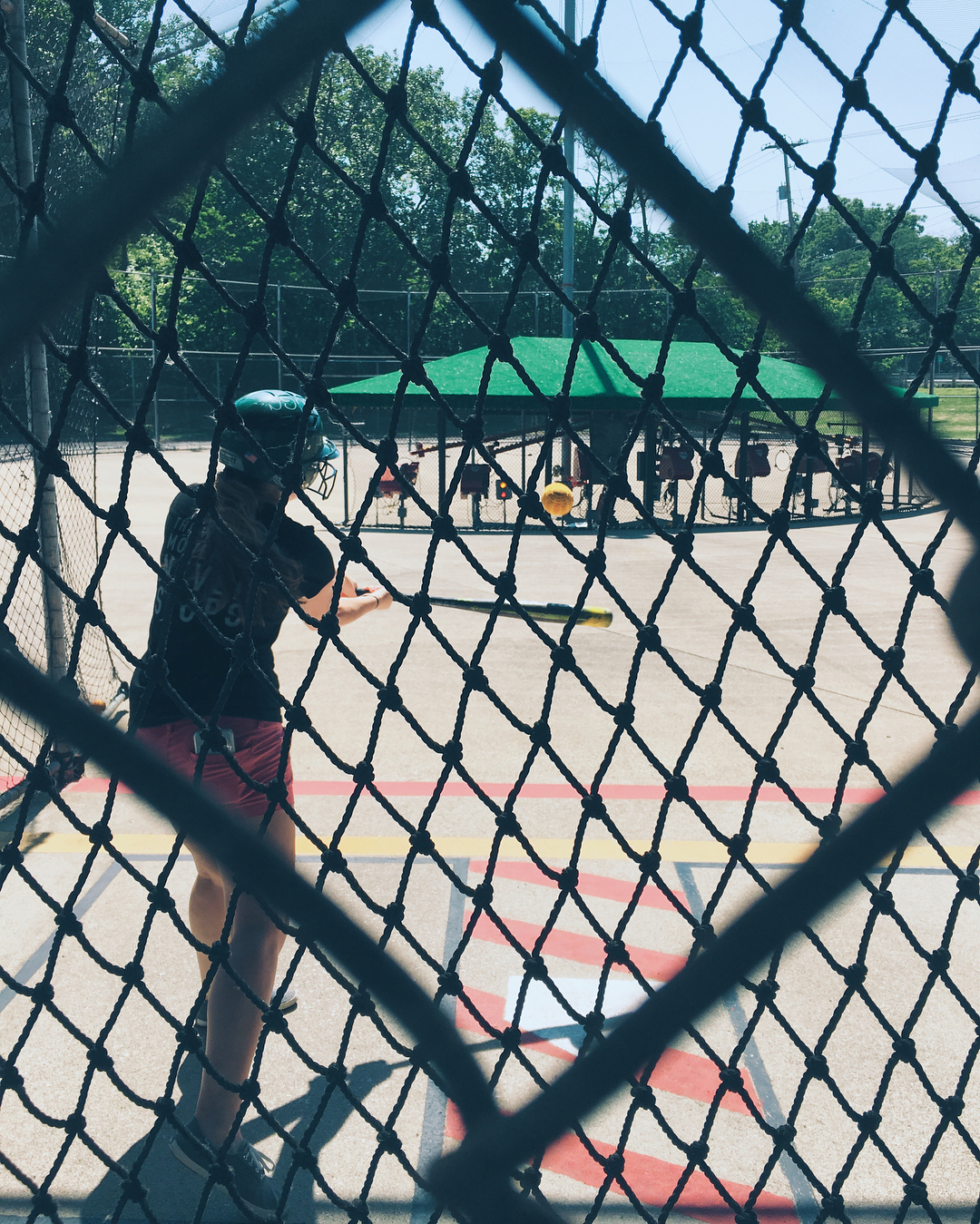 Boy hits ball in batting cage