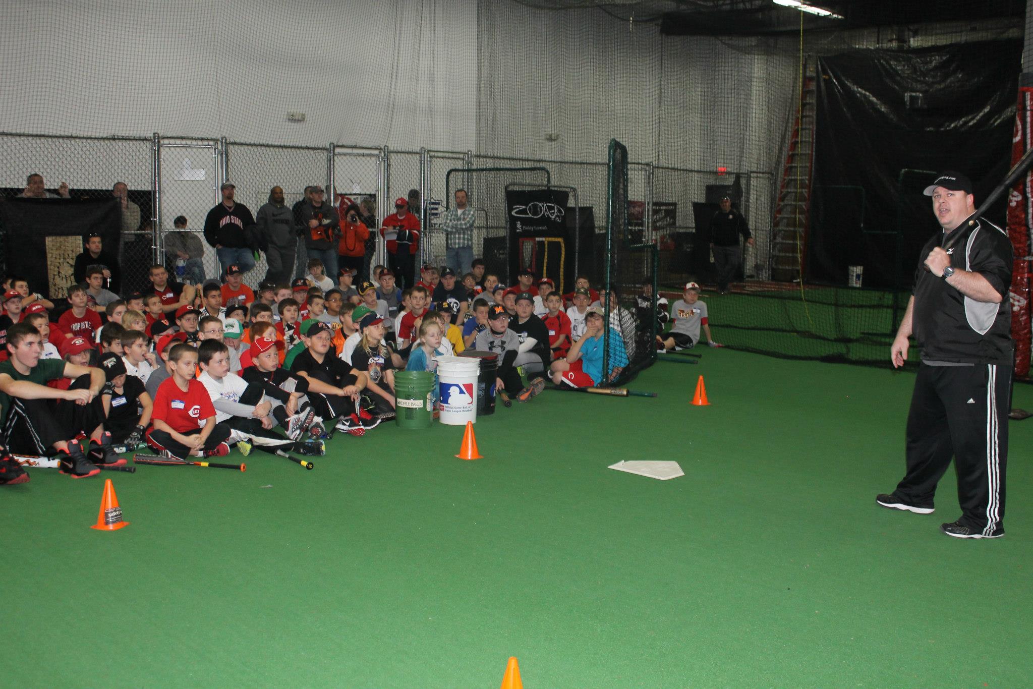 A class full of children being lectured on batting