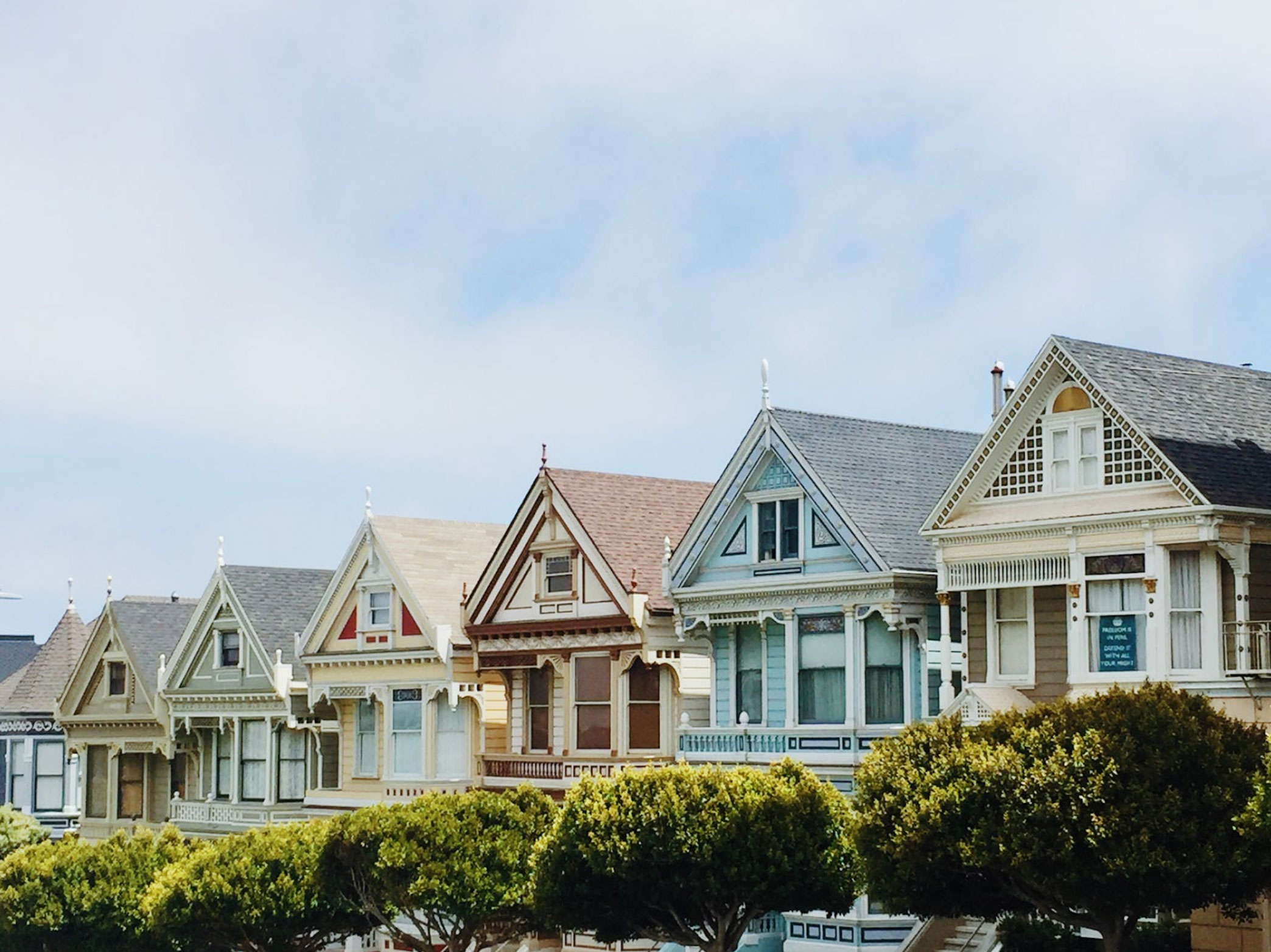 suburban homes under a pale blue sky