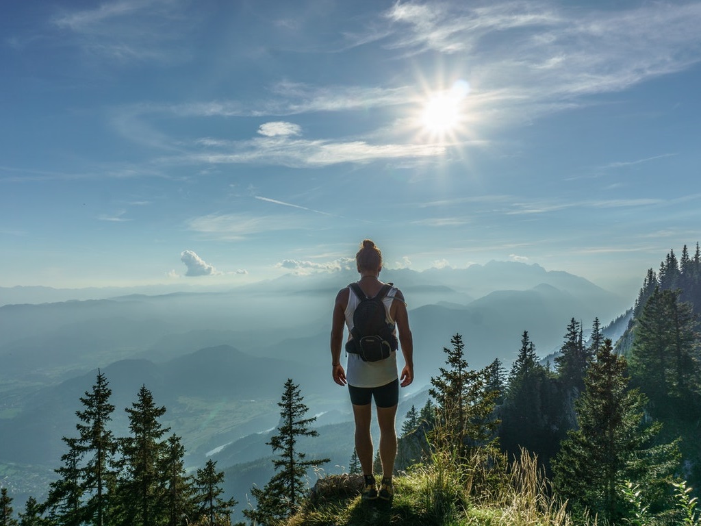 a hiker standing a the top of a hill