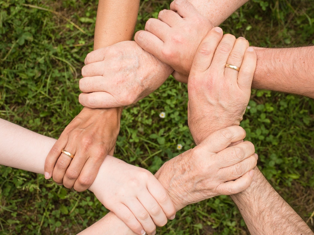 five people holding onto each other's hands