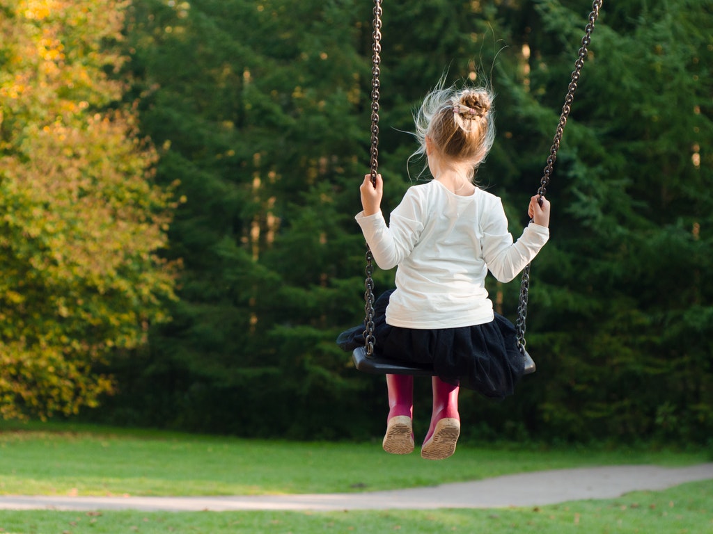 a little girl on a tree swing