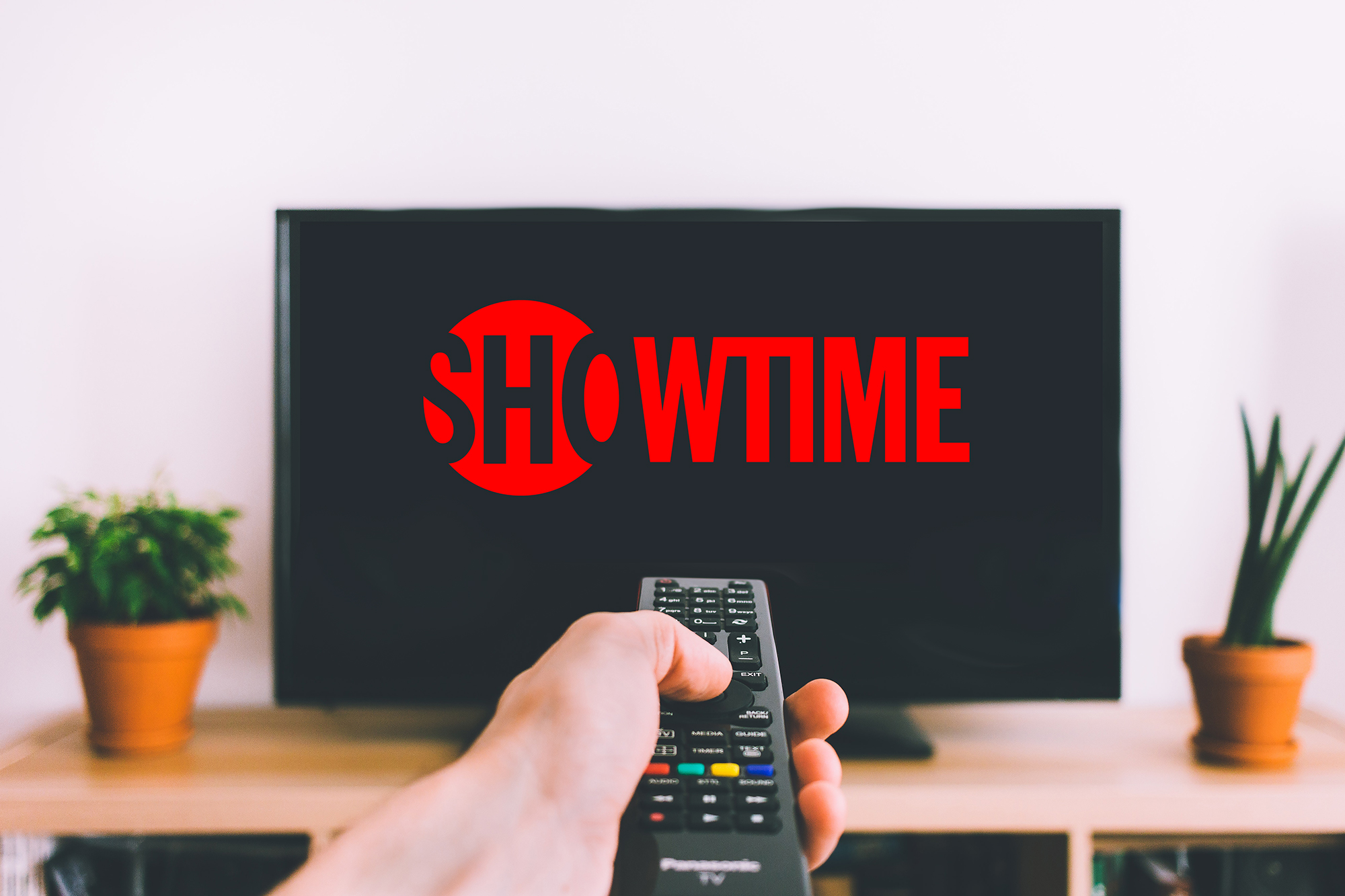 a person putting showtime on a tv