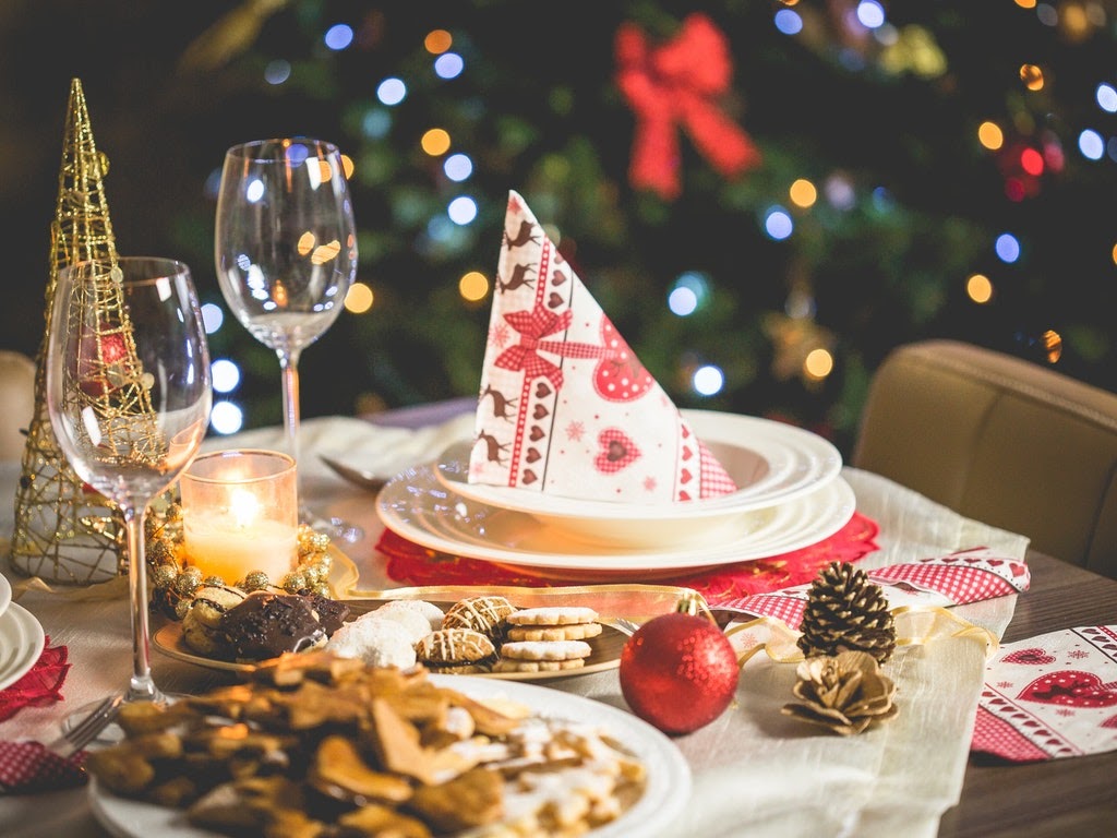 A Christmas place setting with a tree in the backgroundw
