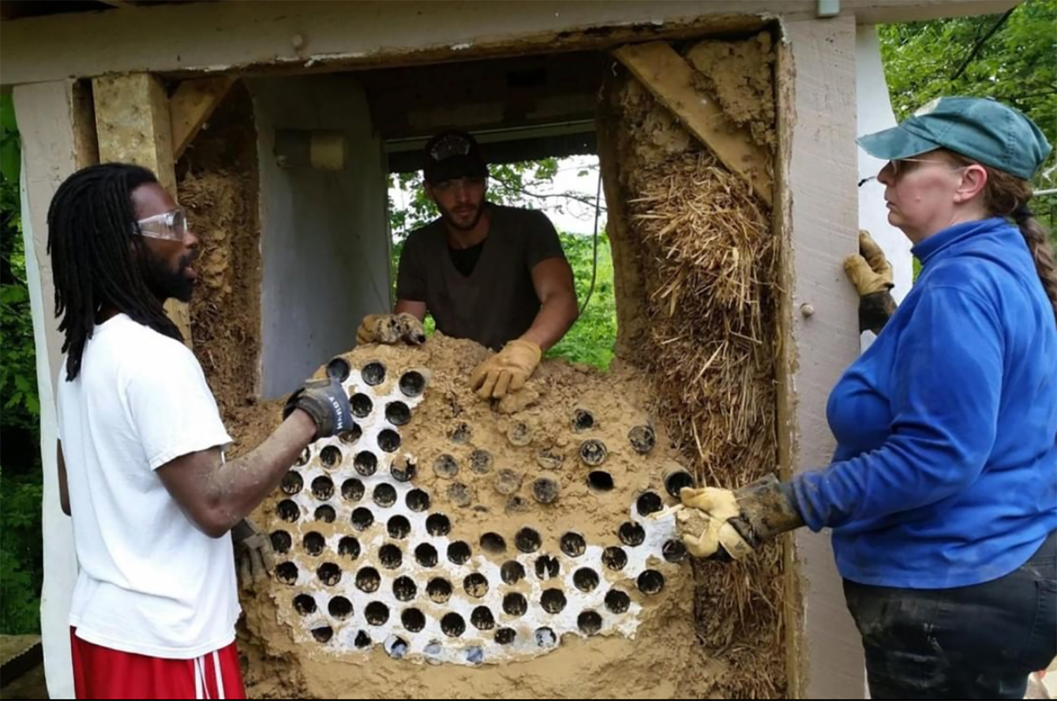 Three men working on the earthship together