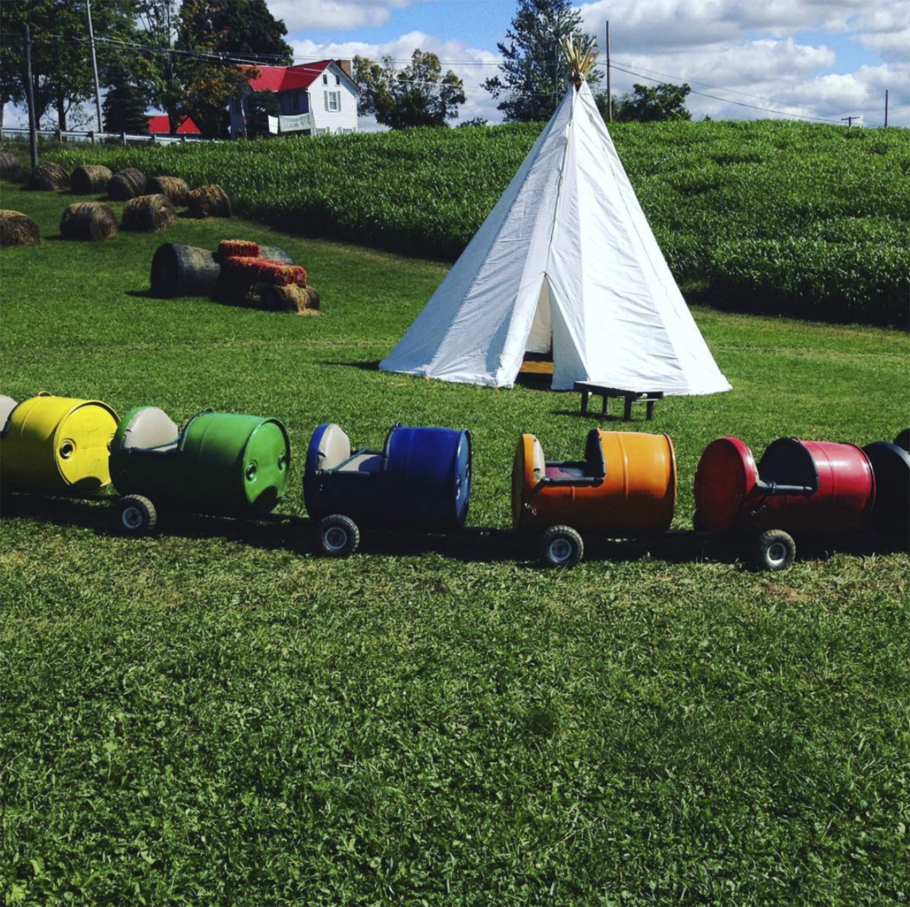 A tee pee surrounded by a little train for children to ride