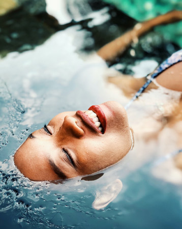 A woman smiling while floating in water