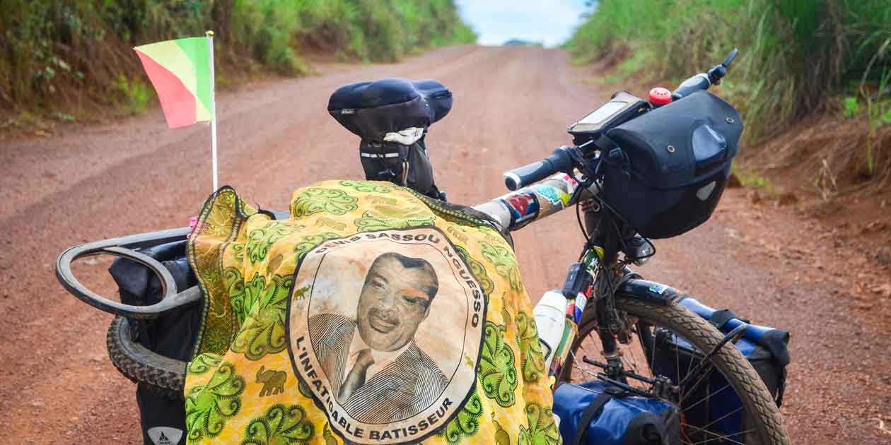 A flag with a portrait of Congo’s President, Denis Sassou Nguesso, lies draped over a road bike.