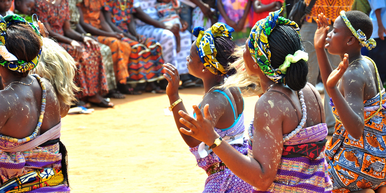 Women from Ghana dance at an event to raise community awareness about healthy behaviors.