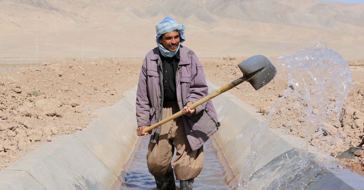 A farmer irrigates a field from a canal improved by the On-Farm Water Management Program in Herat, Afghanistan. He says that before the canal floor was cemented and new sluices established, villagers had many problems irrigating their farms. Photo by Ghulam Abbas Farzami/World Bank, via Flickr, licensed under (CC BY-NC-ND 2.0).