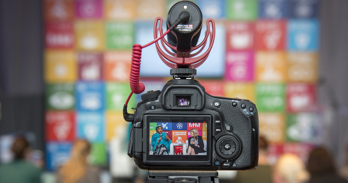 A camera records Deputy Secretary-General Amina Mohammed (left) at the SDGs Media Zone in 2017. Photo by UN/Cia Pak via Flickr, licensed under (CC BY-NC-ND 2.0).