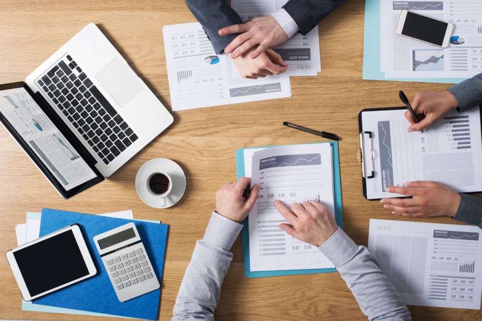 People sitting around a desk with documents