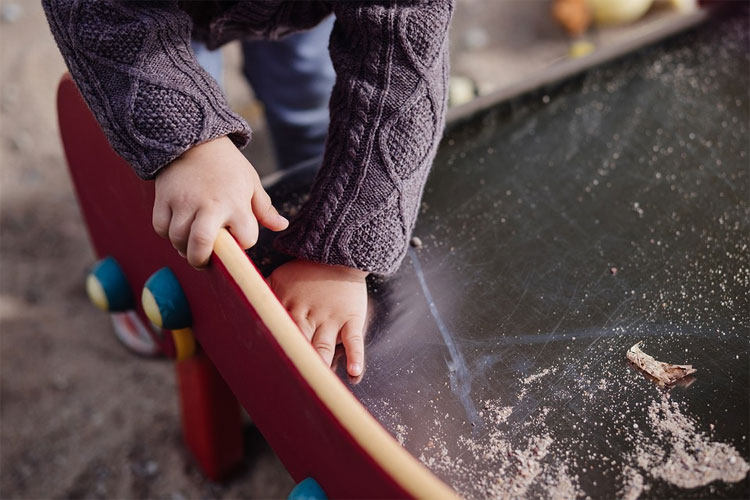 Pest control policies and procedures cover indoor and outdoor settings like this sandpit where a child plays in a child care centre