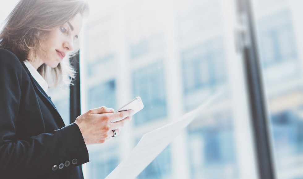woman in business attire looking at phone