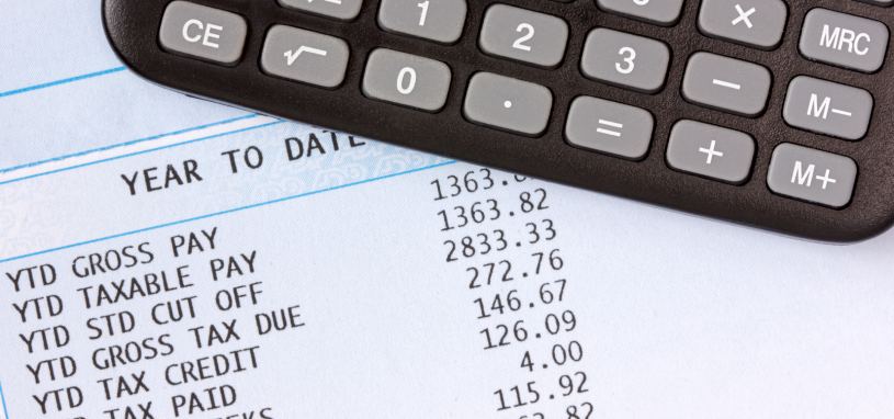 calculator on top of statement of payroll details