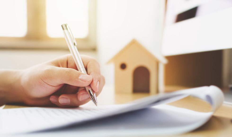 close up of a man's hand signing a contract