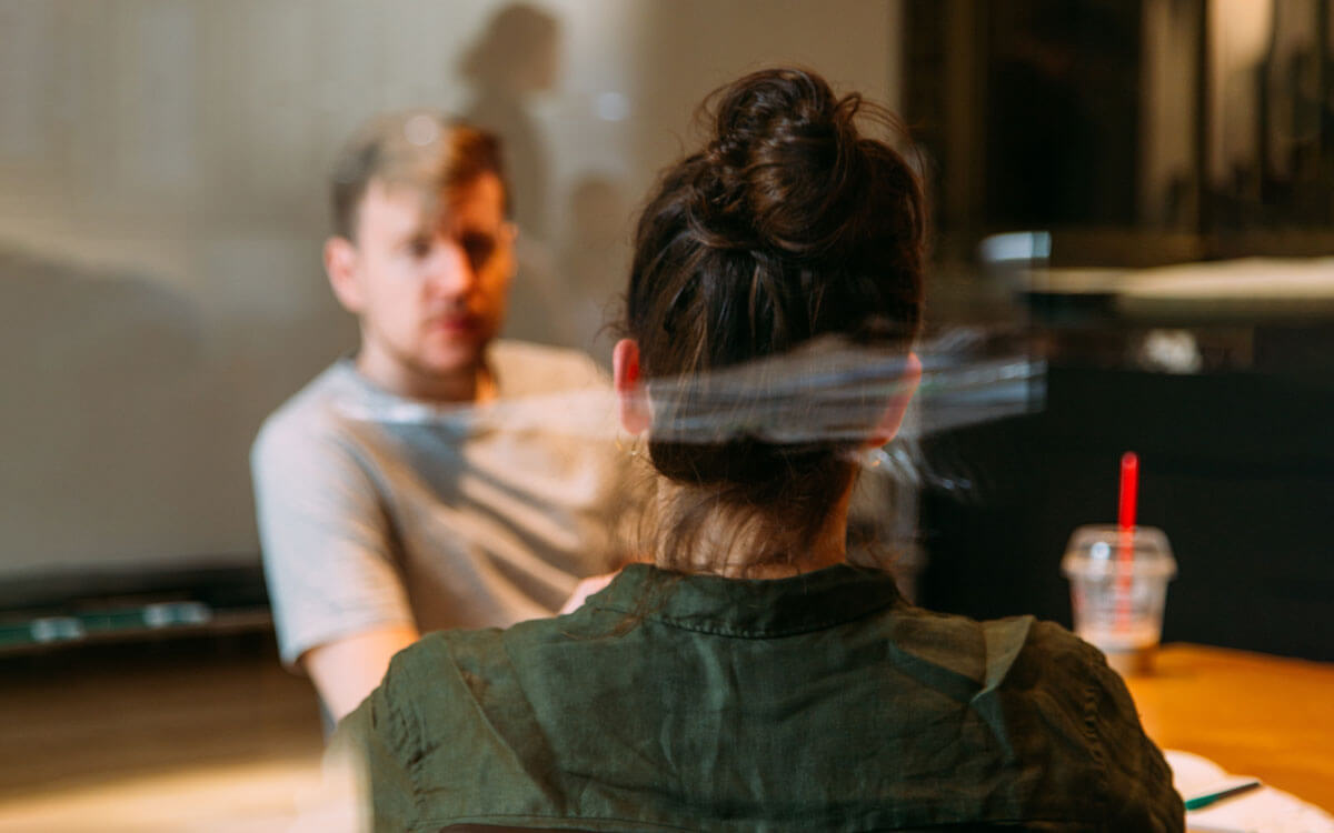 Two humans, male and female sitting in front of each other in the office environment