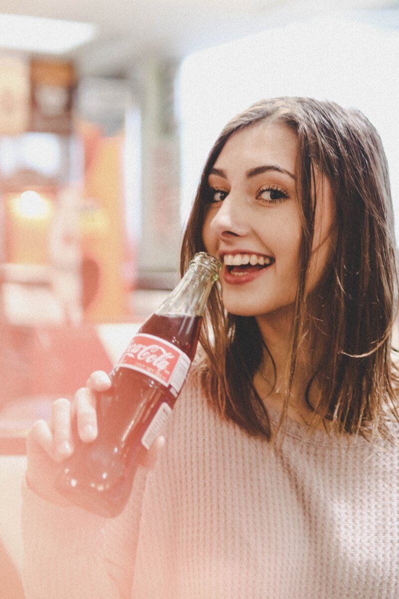 Smiling woman holding Coke bottle