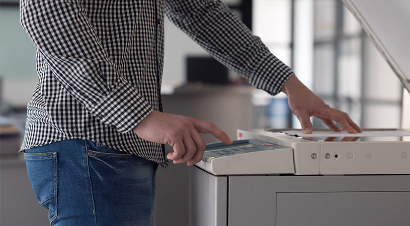 man pressing button on photocopier