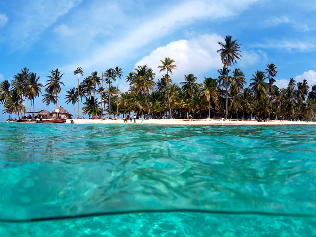 Woman in swimsuit on a swing in tropical location.