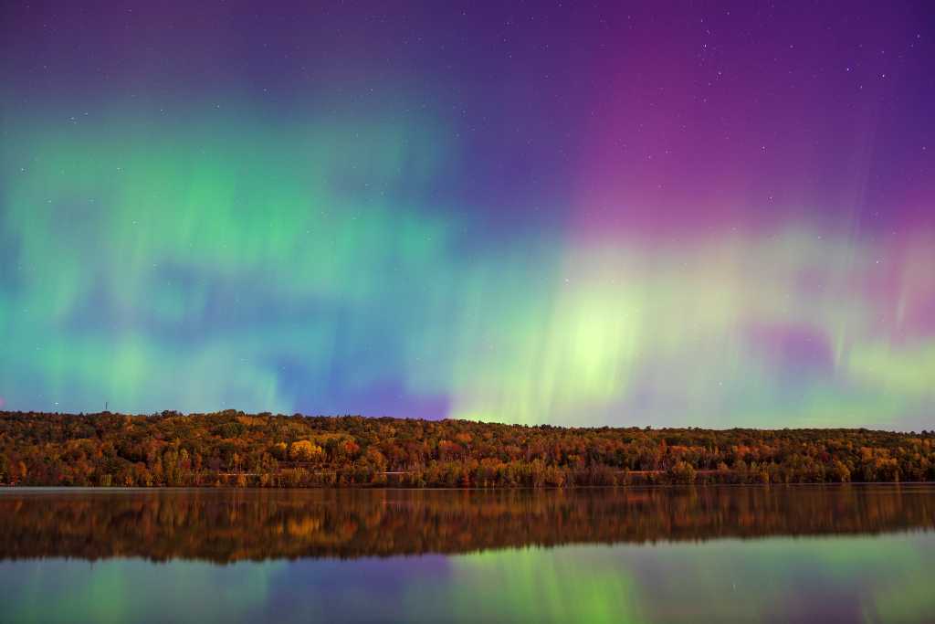 colorful northern lights over lake.