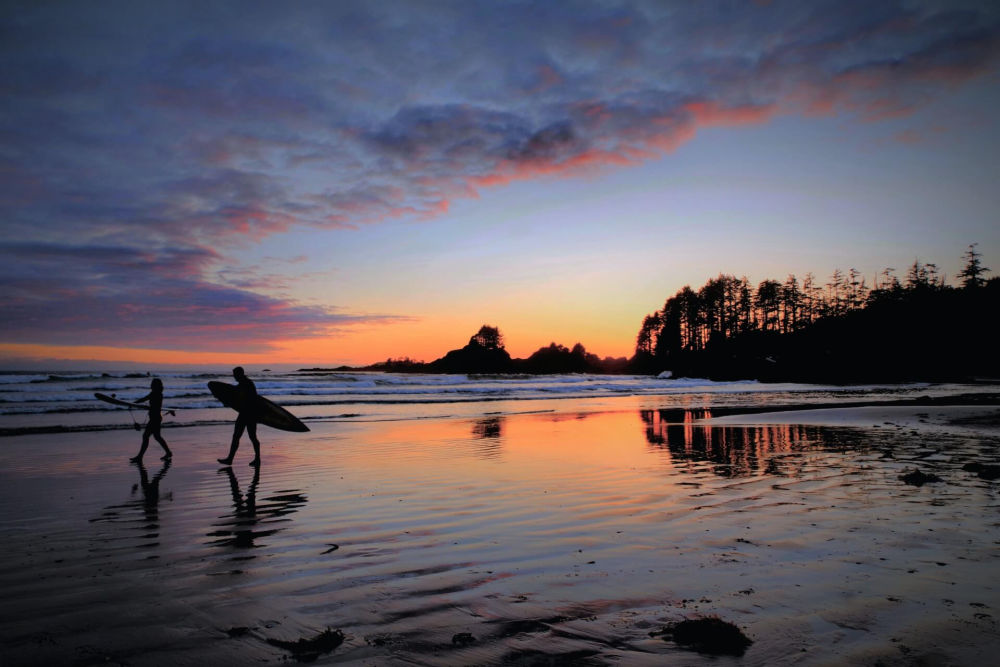 surfers on beach on Vancouver Island.