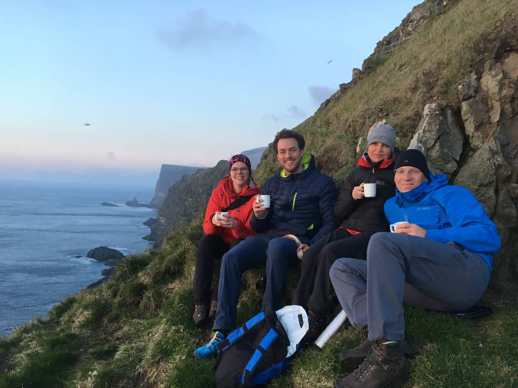 group sitting on the clifs near Mykines