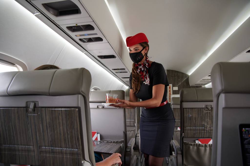 flight attendant serving passengers n JSX.