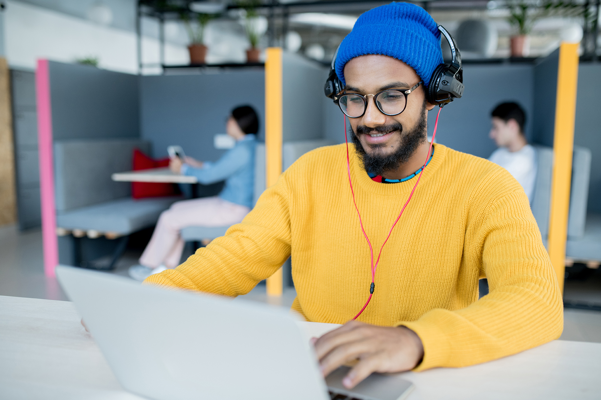 man listening to podcast in coworking space