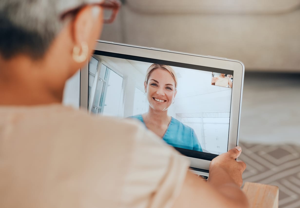 A patient speaks with a telehealth nurse on her laptop.