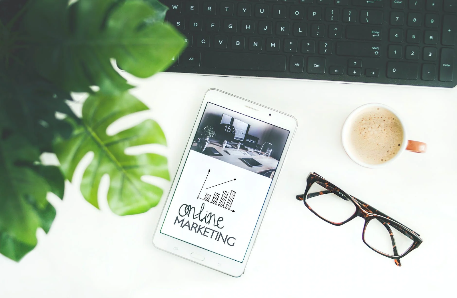 online marketing on smartphone, glasses, coffee, keyboard, plant