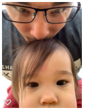 Father kissing his daughter's head as they take a close up selfie