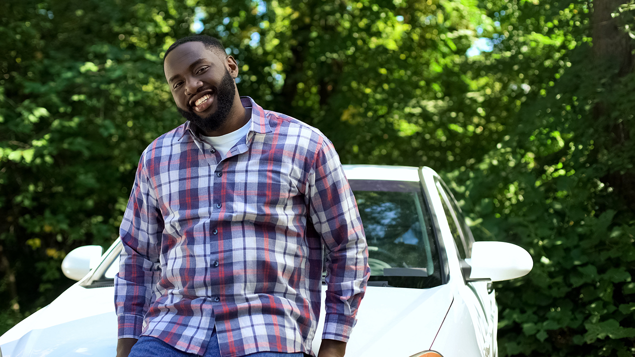 Getaround® power host leaning on a shared car.