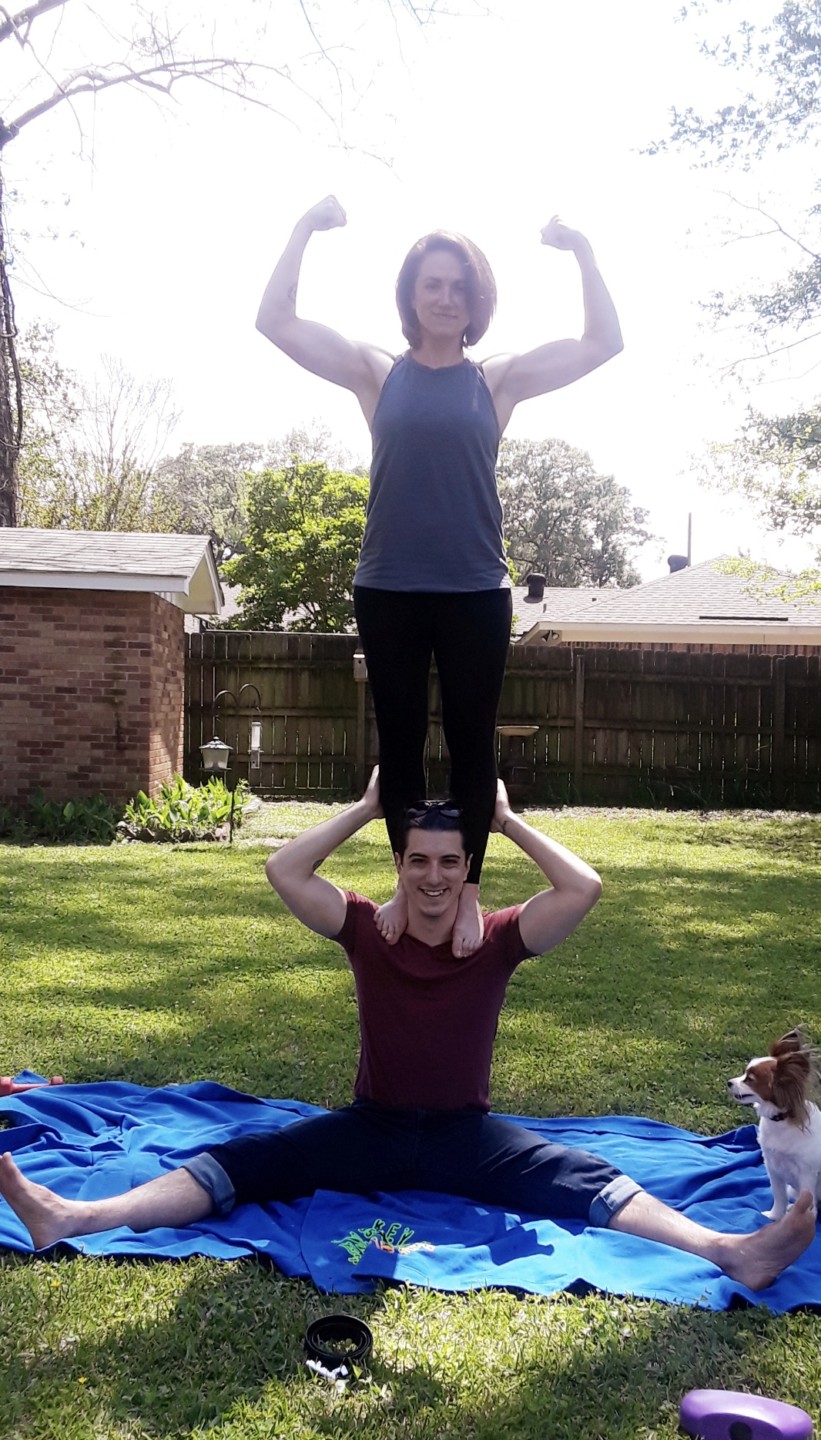 nurse ashley bowlin flexing while standing on man's shoulders