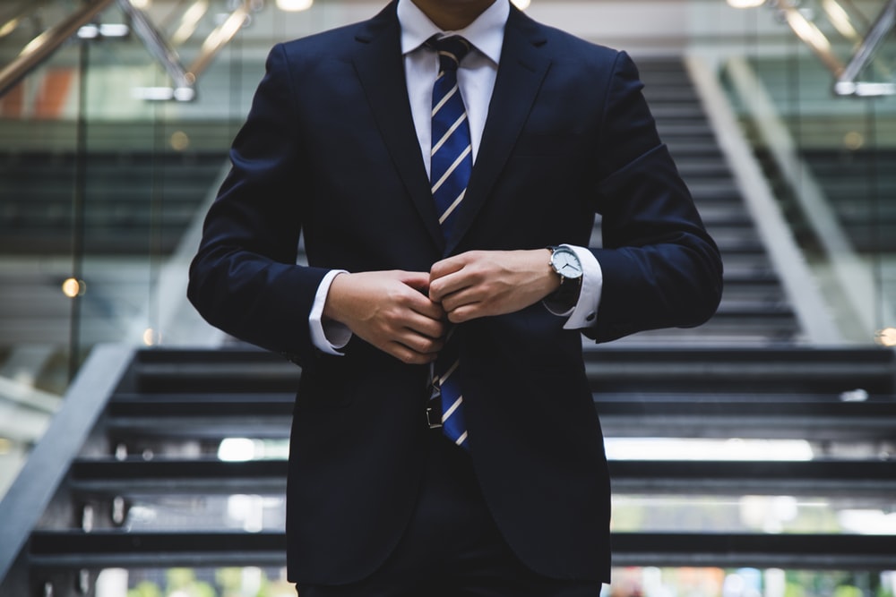 person standing near stairs wearing suit and tie